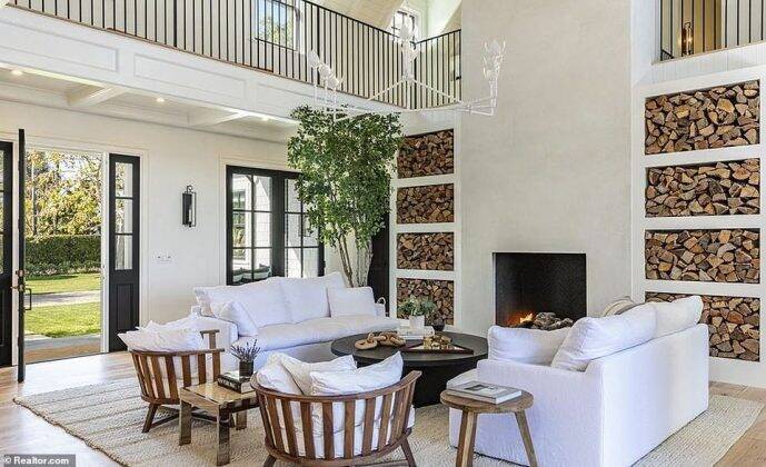 The living room has high ceilings that look onto the second level and French windows (Photo: Release)