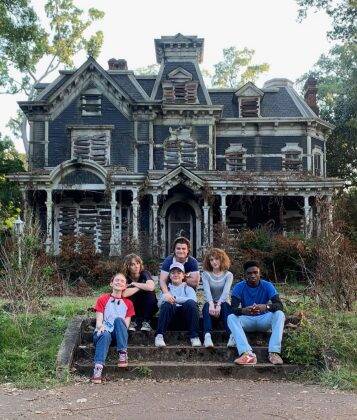 The actors in front of Hugo's house, a key part of the villain's origin. (Photo: Netflix release)