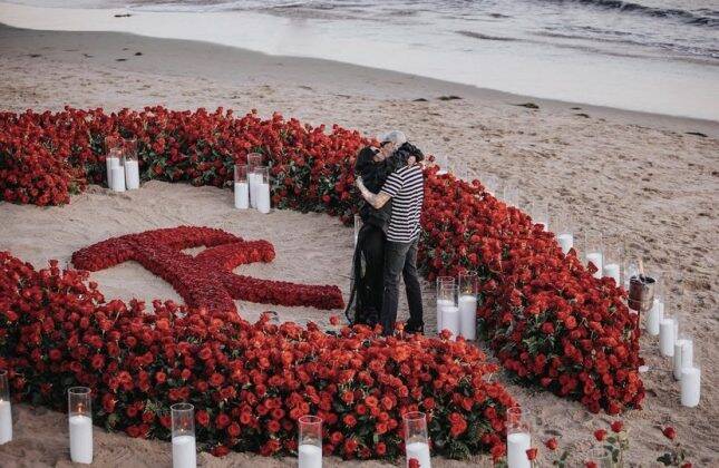 The drummer knelt amid hundreds of red roses and white candles lit in a surprise set up together with the Kardashian family. (Photo: Instagram release)