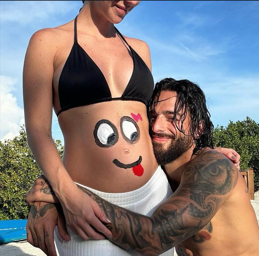 On Halloween, he shared a photo posing with Gomez, showing her belly painted with a face and a bow. (Photo: Instagram)